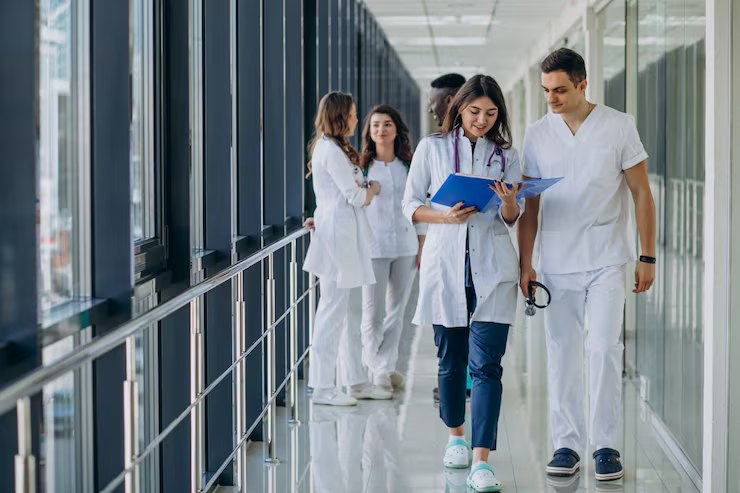 Clinicians walking a hospital corridor, reviewing a patient file.